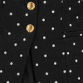 Detalle de botones dorados y puntos blancos del chaleco negro