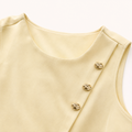 Detalle de botones dorados del Wrap Top amarillo